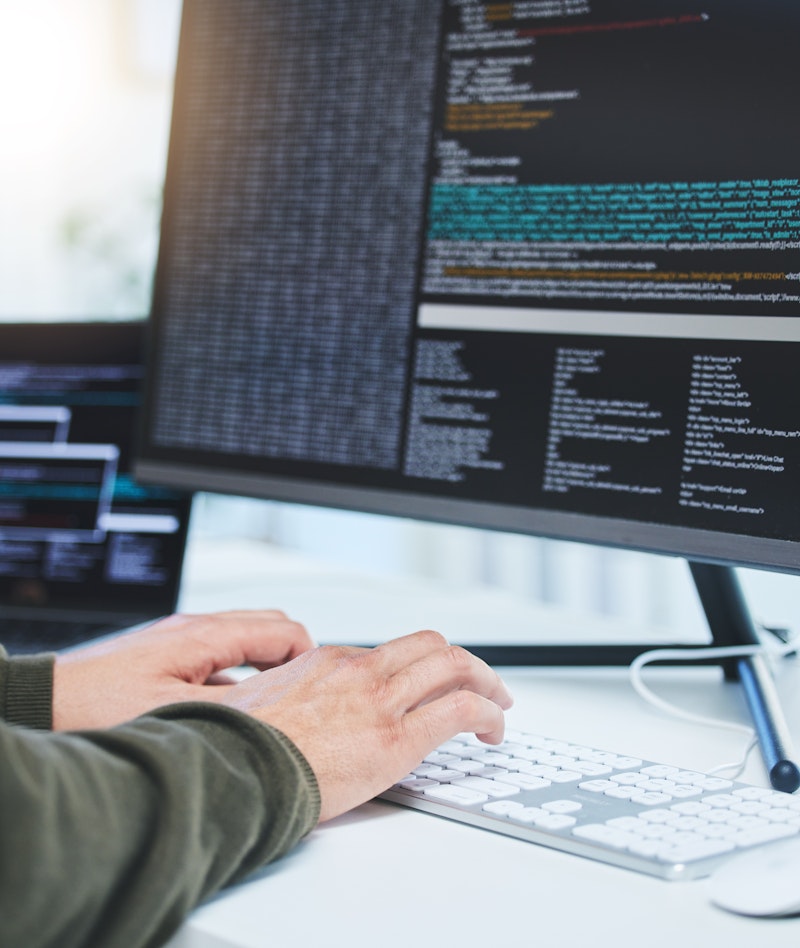 Programmer At Computer Typing At Keyboard