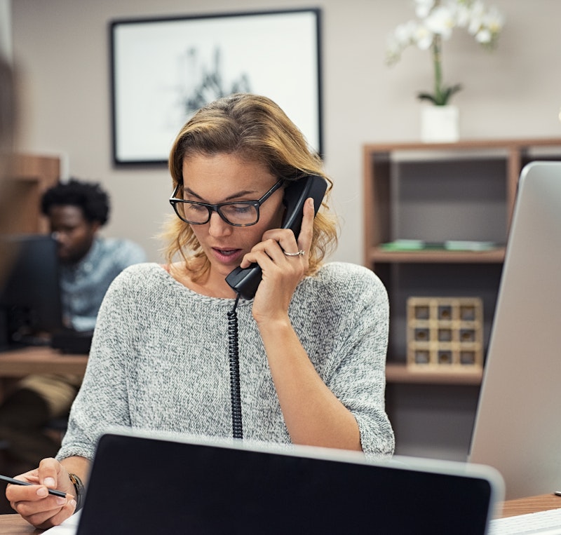 Woman Speaking On Phone In Office