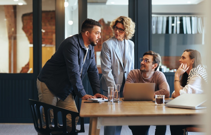 Team Of People Working At A Table In Discussion