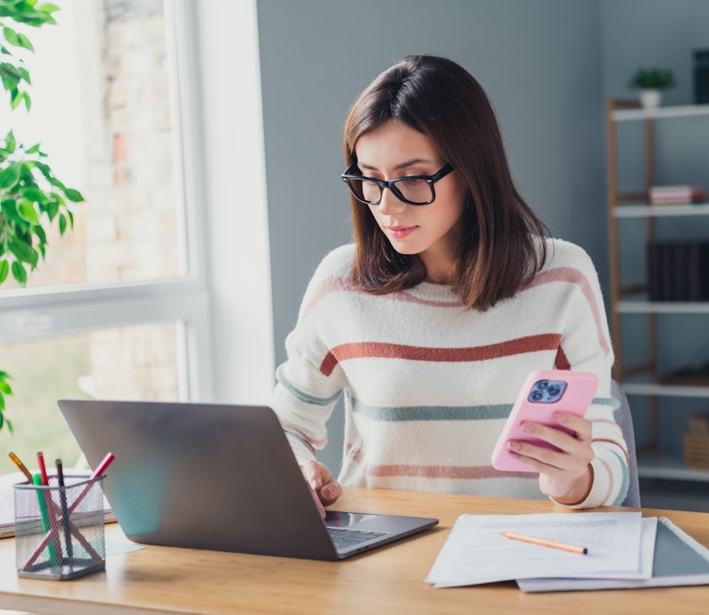 Woman Using Phone And Computer
