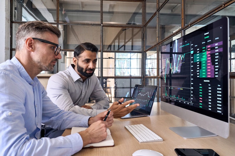 Two Men In Discussion With Computers