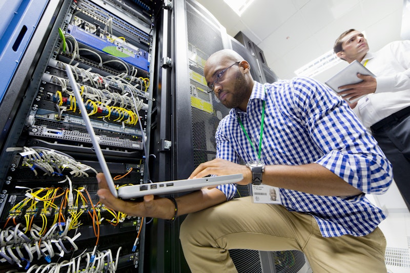 Man With Data Server Room On Laptop