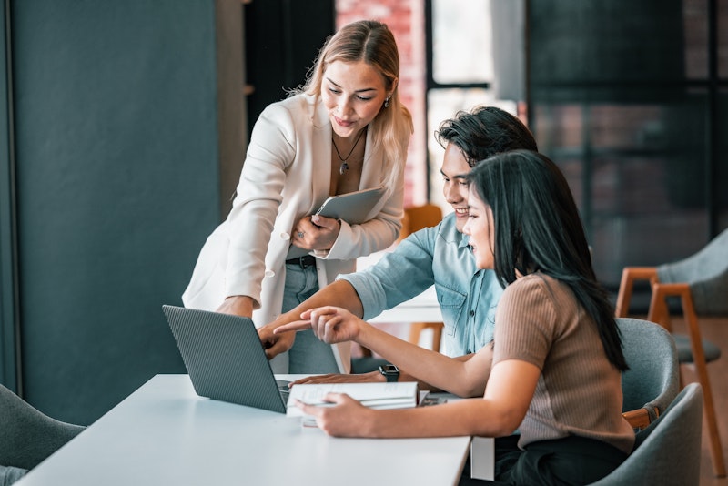 Professor Helping Students On Computer