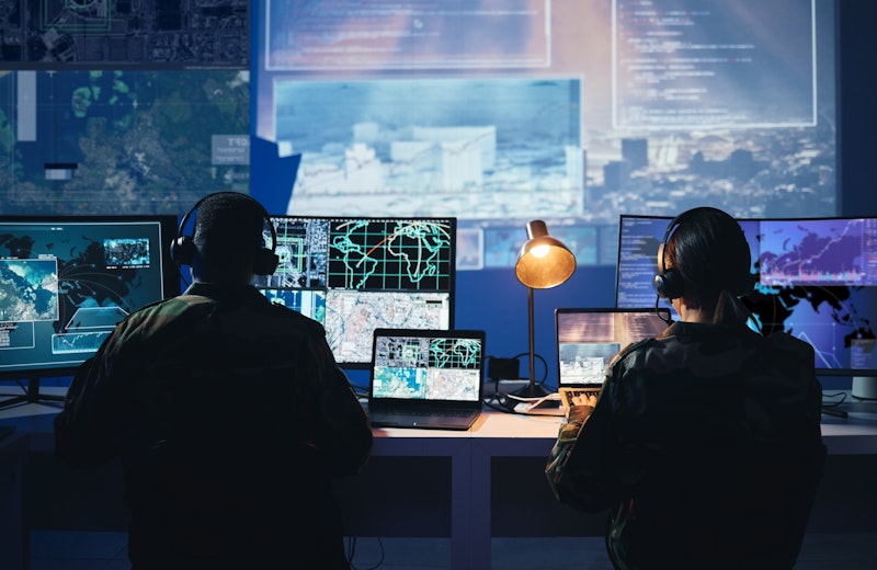 Military Control Room With People Sitting At Desk