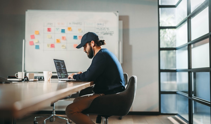 Male Developer At A Comference Table Working